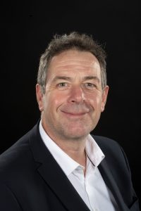 Tony Chambers - he is wearing a dark suit and a white shirt