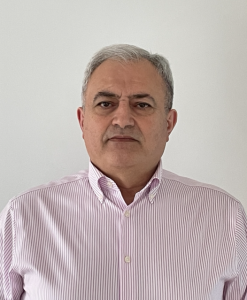 Dr Raad Makadsi, Consultant Rheumatology, wearing a pink and white striped shirt.