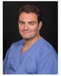 Dr Luke Banks, Consultant Anaesthetist, in blue scrubs.